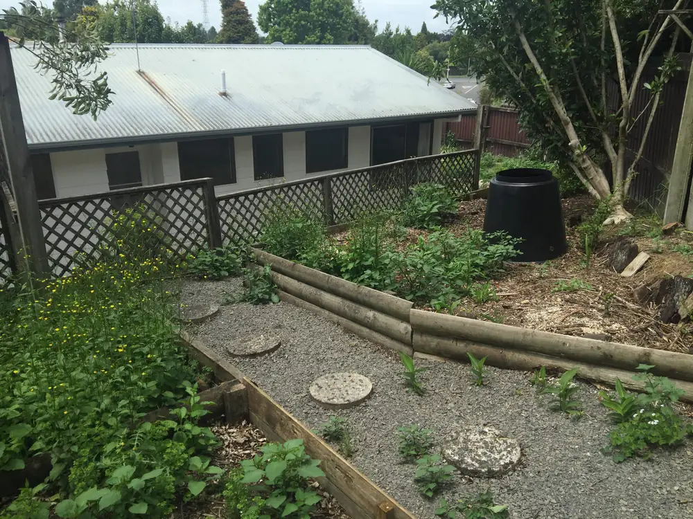 Garden beds with a gravel path, stepping stones and timber edging